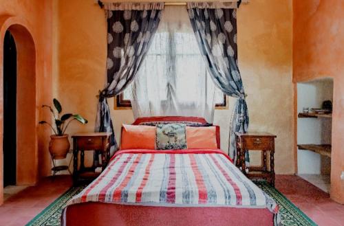 a bedroom with a red bed and a window at Hajrienne guest house in Tangier