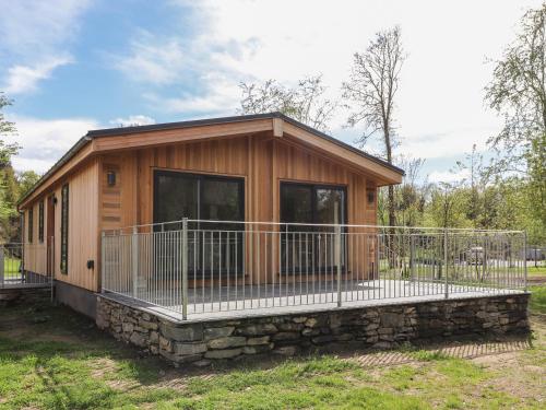 a log cabin with a porch and a fence at Blackthorn Copse in Ulverston