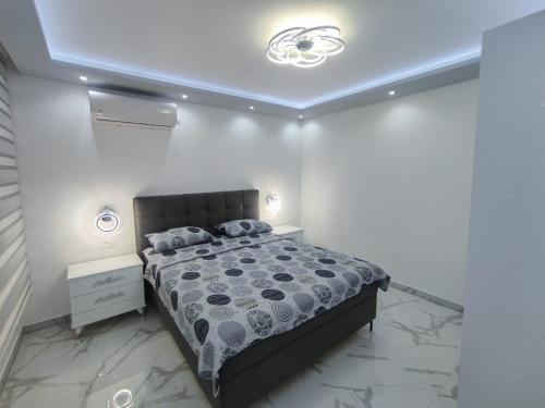 Apartman Viktor في إيغالو: غرفة نوم بسرير في غرفة بيضاء