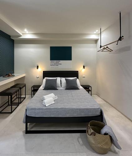 a bedroom with a large bed and a kitchen at D'Aleammare - Rooms in Mattinata
