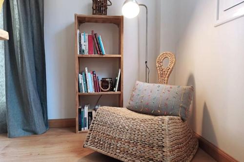 una habitación con una silla y una estantería con libros en La casica de Sabi, en Sabiñánigo