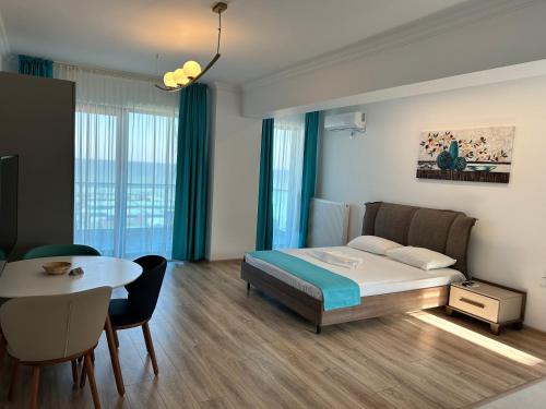 een slaapkamer met een bed en een tafel en een eetkamer bij North Club Apartments II in Mamaia