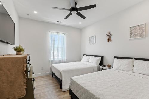 a bedroom with two beds and a ceiling fan at Oasis by Seaport Stays in Wildwood