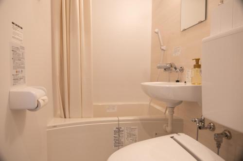 a bathroom with a toilet and a sink at HOTEL BOTH in Shari