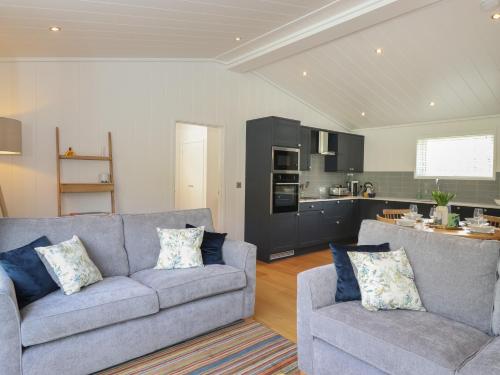 a living room with two couches and a kitchen at Hawthorn Croft in Ulverston