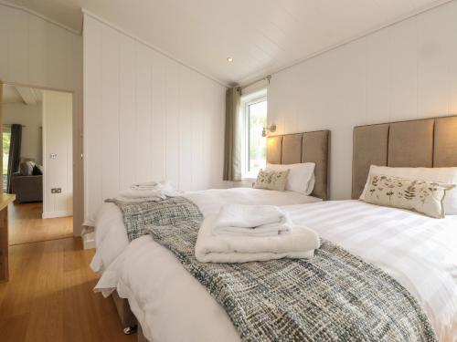 una camera bianca con due letti e asciugamani di The Yews a Ulverston