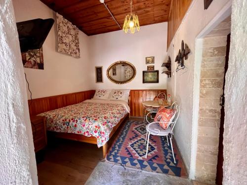 a bedroom with a bed and a table and a mirror at Mystic Konak in Selçuk