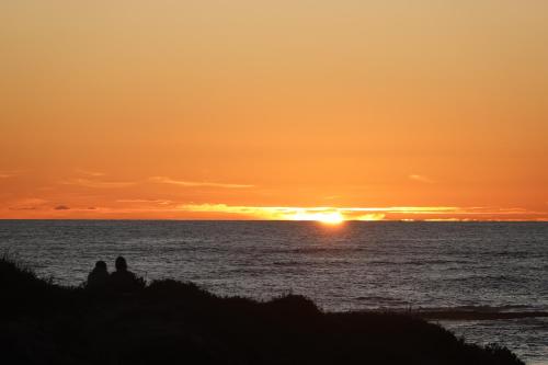 two people sitting on the beach watching the sunset at Soutelande Country Stay - Close to 1#Beach in PE in Port Elizabeth