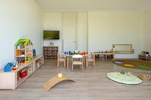 a living room with a table and a room with toys at Meliá Calviá Beach in Magaluf