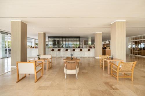 a restaurant with tables and chairs in a building at Meliá Calviá Beach in Magaluf