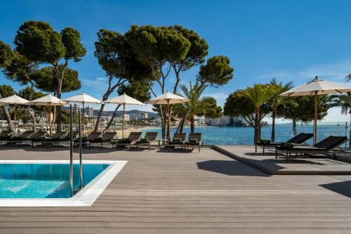 a resort with a pool and chairs and umbrellas at Meliá Calviá Beach in Magaluf