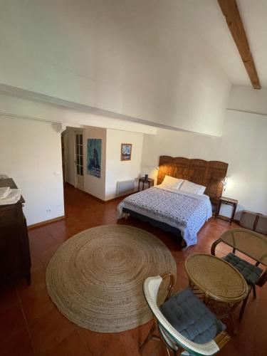 穆斯捷-圣玛丽Chambres d' hôtes l'Escalo à Moutiers-Ste-Marie (04360)的一间卧室，配有一张床、一张桌子和几把椅子