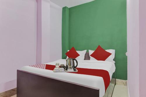 a bedroom with a bed with red and green walls at OYO Sun Shine Hotel Laxmi Nagar in New Delhi