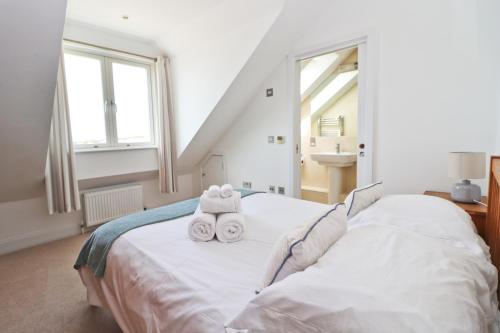 a bedroom with a bed with two towels on it at SEA VIEWS, beachside apartment with balcony in Saint Merryn