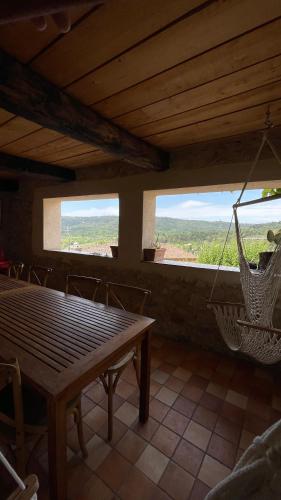 a dining room with a table and chairs and a swing at Chambres d' hôtes l'Escalo à Moutiers-Ste-Marie (04360) in Moustiers-Sainte-Marie