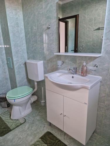 a bathroom with a toilet and a sink and a mirror at Splendid Aparthotel in Năvodari