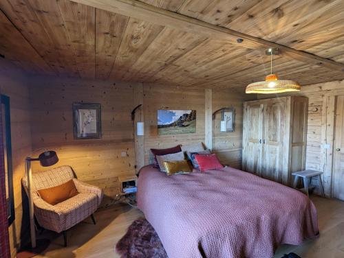 a bedroom with a large bed and a chair at Bas de chalet au coeur des Aravis, entre lac et montagne in Saint-Jean-de-Sixt