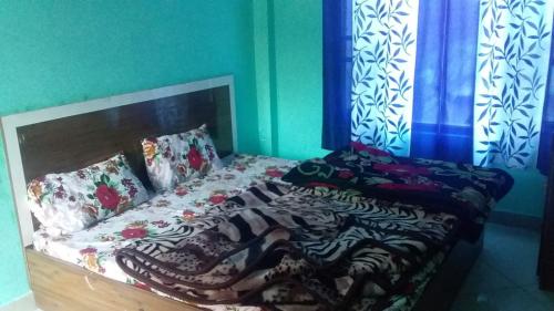 a bed in a room with blue walls at SPOT ON Sharma's Kitchen & Home Stay in Bajaura