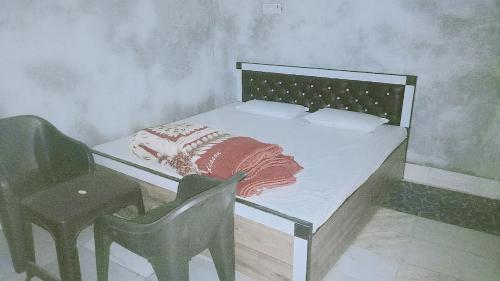a bedroom with a bed with a chair and a desk at SPOT ON Green Hotel in Meerut