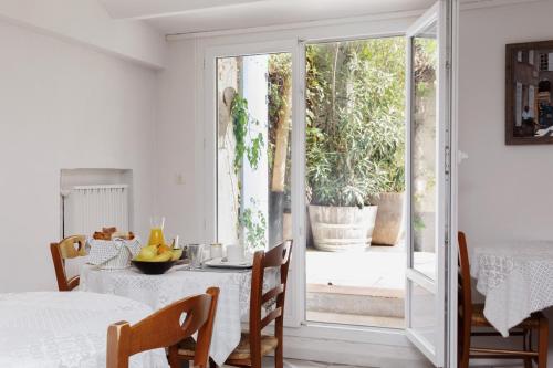 a white dining room with a table and a sliding glass door at Coq Hotel in Cogolin