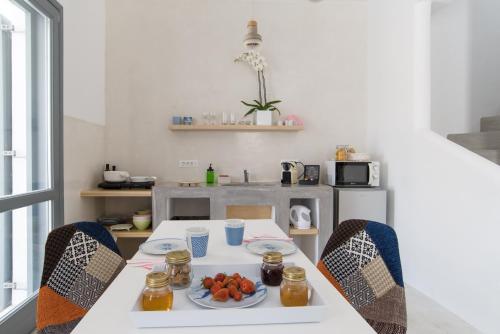 a kitchen with a table with a plate of fruit on it at LAGADI SUITES by K&K in Mesaria