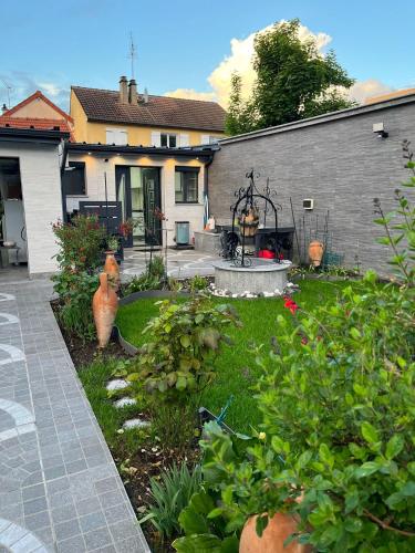 une cour avec un jardin et une maison dans l'établissement SCI Slama FAMILY, à Livry-Gargan