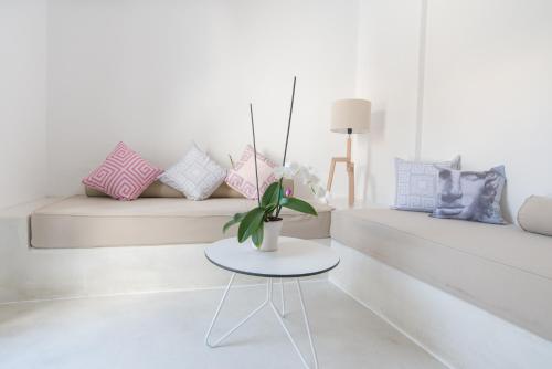 a white living room with a table and a couch at LAGADI SUITES by K&K in Mesaria