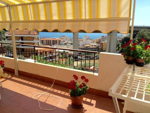 a balcony with flowers and a view of a city at Casa Vacanza Da Rosa in Letojanni