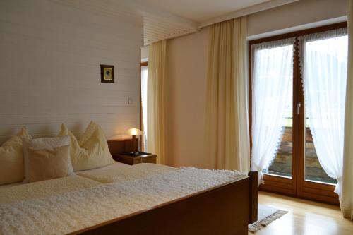 a bedroom with a bed and a large window at Appartementhaus Astl in Sankt Johann in Tirol