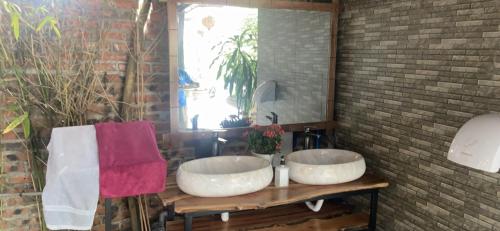 un bagno con due lavandini e uno specchio di CAMELLIA ECO HOME &TRÀ MY RESTAURANT a Ninh Binh