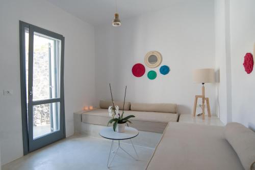 a white living room with a couch and a table at LAGADI SUITES by K&K in Mesaria