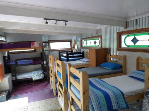 een kamer met meerdere stapelbedden in een huis bij Yellowwood Forest Eco Retreat in Morganʼs Bay