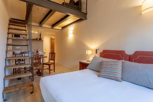 a bedroom with a white bed and a staircase at Ramaglianti Apartments Suite Tre in Florence