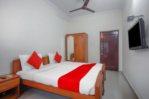 a bedroom with a bed and a tv on a wall at OYO Home Tree Service Apartment Near Saravana Stores T Nagar in Chennai