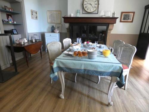 a table with a blue table cloth with food on it at La Maison Florence in Mont-de-Marsan
