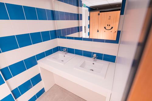 a bathroom with two sinks and a mirror at Hostel Le Hüb Toulon in Toulon