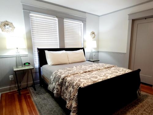 een slaapkamer met een bed, 2 lampen en een raam bij RED DOOR HOUSE in Lakeland