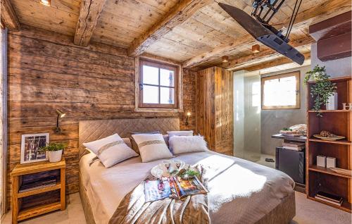 a bedroom with a bed in a room with wooden walls at Chalet Luisa in Predazzo