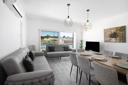 a living room with a couch and a table and chairs at Villa Flora in Algoz
