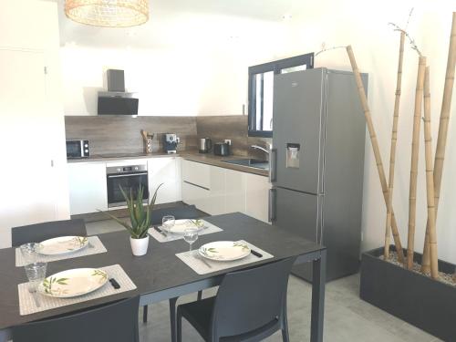 eine Küche mit einem Tisch und einem Kühlschrank in der Unterkunft BELLA CORSICA in Ajaccio