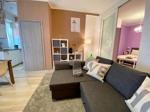 - un salon avec un canapé et une salle à manger dans l'établissement Appartamento Chagall, à Asti
