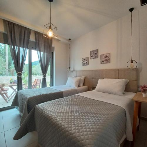 two beds in a room with a window at Dream Time Villa Vasiliki in Vasiliki