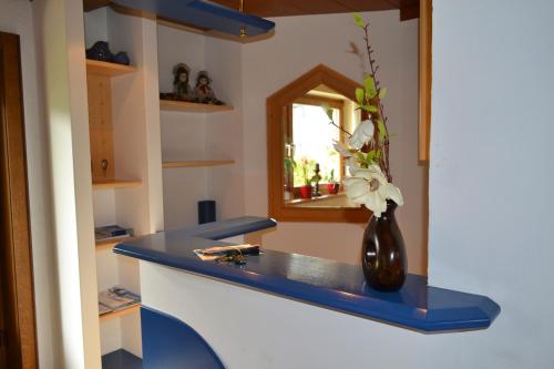 a blue counter with a vase with flowers in it at Appartementhaus Astl in Sankt Johann in Tirol
