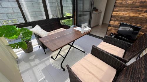 a dining room with a wooden table and chairs at おもてなしハウスさいたま in Saitama