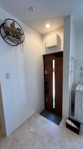a room with a hallway with a wooden door at おもてなしハウスさいたま in Saitama