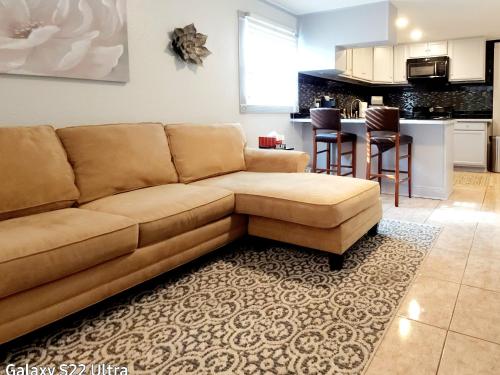 a living room with a brown couch and a kitchen at RED DOOR HOUSE in Lakeland
