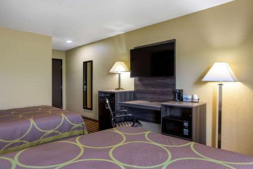 a hotel room with a bed and a flat screen tv at Super 8 by Wyndham Nixa/Springfield Area in Nixa
