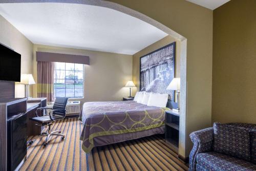 ein Hotelzimmer mit einem Bett, einem Schreibtisch und einem Stuhl in der Unterkunft Super 8 by Wyndham Nixa/Springfield Area in Nixa