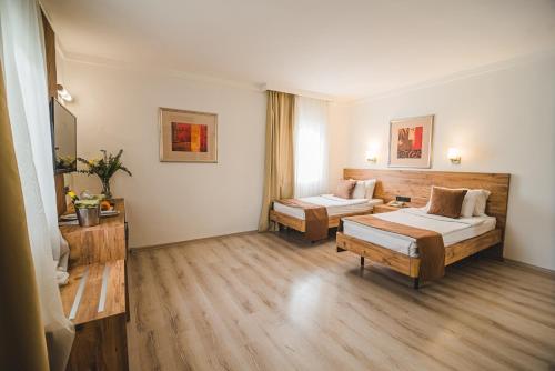 a hotel room with two beds and a couch at UPTOWN Büyük Anadolu Girne Hotel in Kyrenia