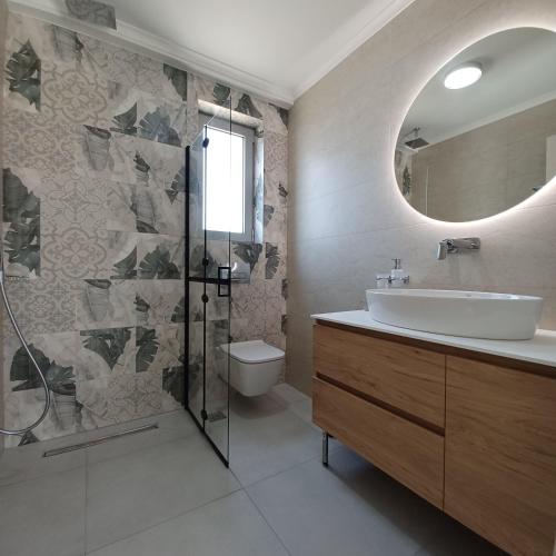 a bathroom with a shower and a sink and a mirror at Dream Time Villa Vasiliki in Vasiliki